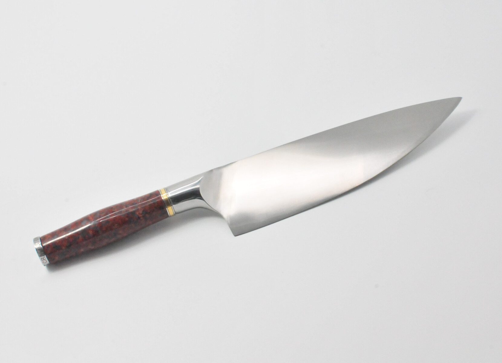 https://www.craftstoneknives.com/wp-content/uploads/bfi_thumb/10-Inch-Chef-Knife-with-a-Red-Granite-Handle-a-Garnet-Colored-Cubic-Zirconia-Stone-at-the-Back-of-the-Knife-and-Brass-and-Stainless-Steel-Decorative-Rings-3jbc4tjwm4olderoghbuh6.jpg