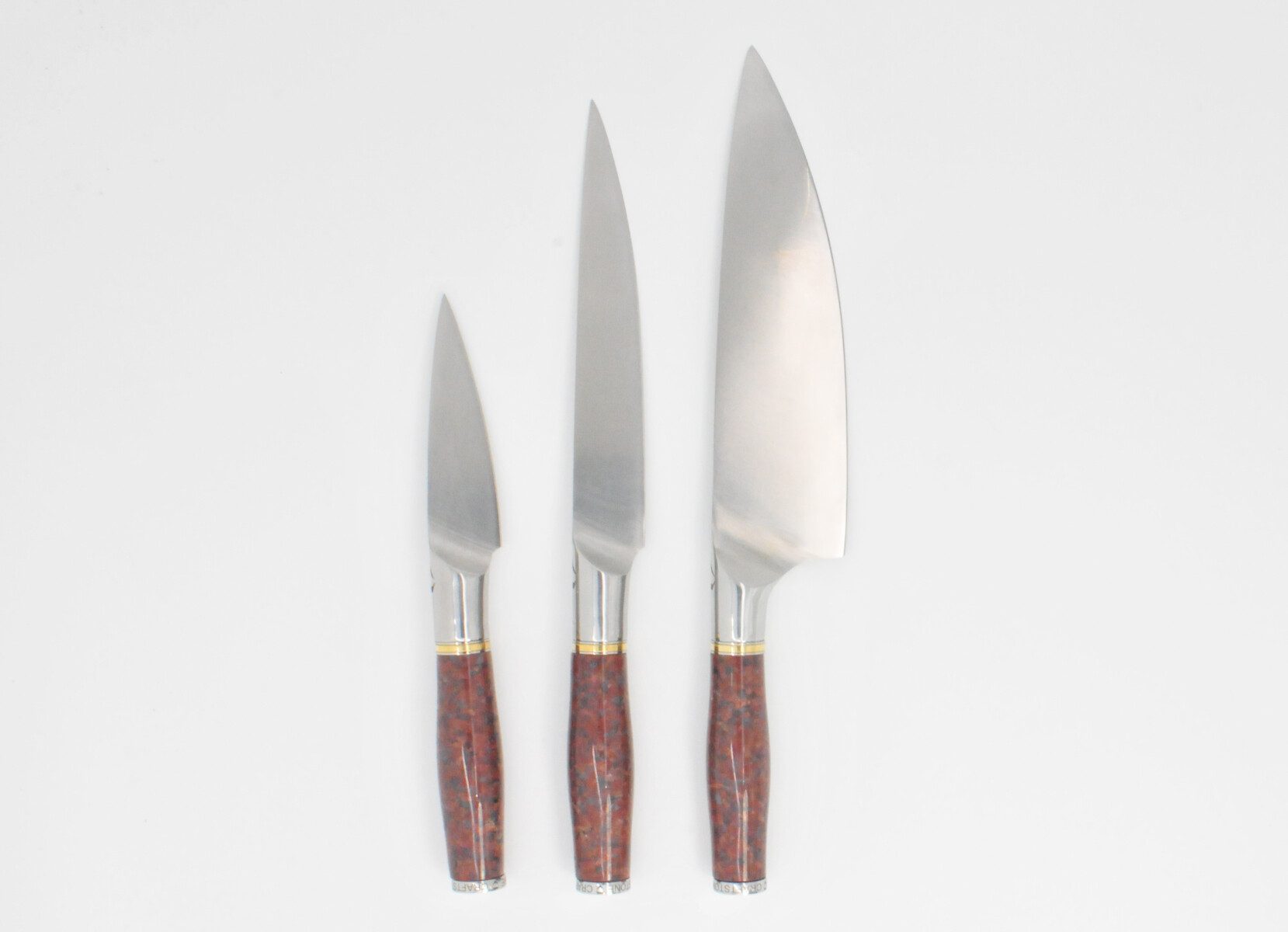 https://www.craftstoneknives.com/wp-content/uploads/bfi_thumb/3-Knife-Set-with-a-Red-Granite-Handle-a-Garnet-Colored-Cubic-Zirconia-Stone-at-the-Back-of-the-Knife-and-Brass-and-Stainless-Steel-Decorative-Rings-3jbc5rcoyu28ygk72i287e.jpg